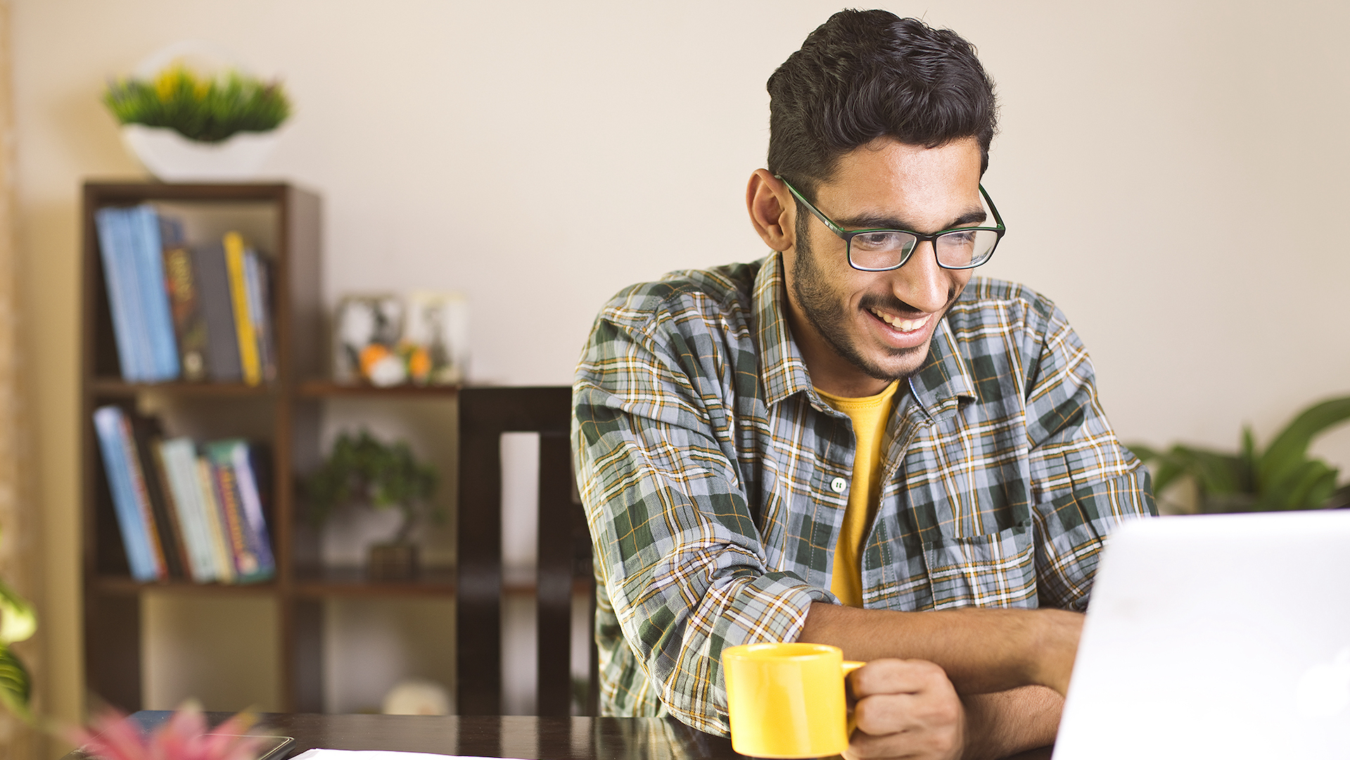 Man using calculator to calculate financial bills in home office.